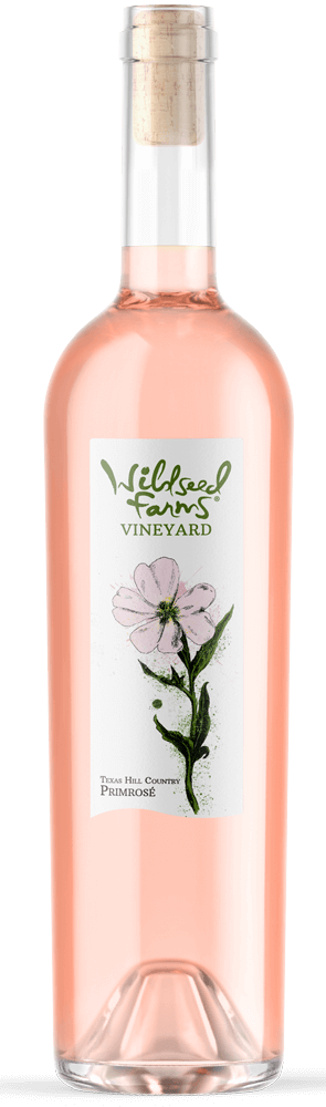 Wildseed Farms & Winery Primrose is a rosé that brings depth and freshness together in a glass. Light ruby in color, it offers red berries, floral spice, and a whisper of rose petal on the nose. Medium-bodied and smooth on the palate, it delivers plenty of fruit without feeling heavy. The vines thrive in sun-exposed slopes with light soils and steady drainage, giving the wine a graceful balance of ripeness and finesse. This is a rosé that pairs just as well with grilled meats as it does with sunset. Bottle Preview